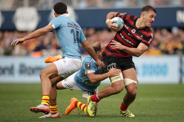 Toulouse's French number eight Theo Ntamack (R) is tackled by Perpignan's Argentine fly-half Benjamin Urdapilleta (C) during the French Top 14 rugby union match between USA Perpignan and Stade Toulousain (Toulouse) at the Aime-Giral stadium in Perpignan, south-western France on January 3, 2026. (Photo by Valentine CHAPUIS / AFP)