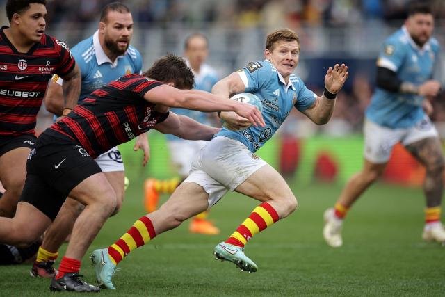 Perpignan's English scrum-half James Hall (C) is tackled during the French Top 14 rugby union match between USA Perpignan and Stade Toulousain (Toulouse) at the Aime-Giral stadium in Perpignan, south-western France on January 3, 2026. (Photo by Valentine CHAPUIS / AFP)