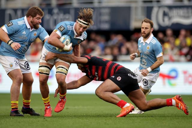 Perpignan's Scottish flanker Jamie Ritchie (2nd L) is tackled during the French Top 14 rugby union match between USA Perpignan and Stade Toulousain (Toulouse) at the Aime-Giral stadium in Perpignan, south-western France on January 3, 2026. (Photo by Valentine CHAPUIS / AFP)
