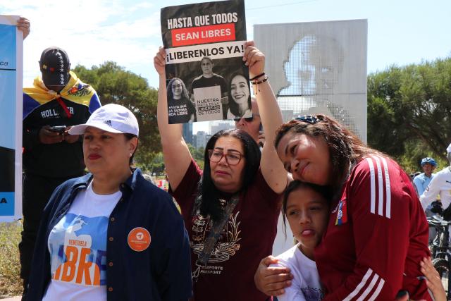 A Venezuelan woman living in Ecuador holds up a sign reading "Until they are all free. Free them now!", referring to people detained in Venezuela, during a gathering in Quito on January 3, 2026, after US forces captured Venezuelan leader Nicolas Maduro. President Donald Trump said Saturday that US forces had captured Venezuela's leader Nicolas Maduro after bombing the capital Caracas and other cities in a dramatic climax to a months-long standoff between Trump and his Venezuelan arch-foe. (Photo by Galo Paguay / AFP)