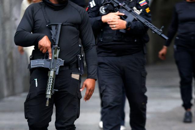 Members of the National Direction of Military Counterintelligence of Venezuela, walk near the Miraflores presidential palace in Caracas on January 3, 2026, after US forces captured Venezuela's President Nicolas Maduro. President Donald Trump said Saturday that US forces had captured Maduro after bombing the capital Caracas and other cities in a dramatic climax to a months-long standoff between Trump and his Venezuelan arch-foe. (Photo by Pedro MATTEY / AFP)