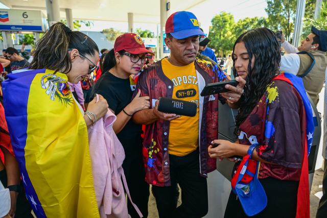 People react to the news of the capture of Venezuelan President Nicolas Maduro, after US military actions in Venezuela this morning, in Doral, Florida, near Miami on January 3, 2026. President Trump said Saturday that US forces had captured Venezuelan leader Nicolas Maduro after launching a "large scale strike" on the South American country. (Photo by GIORGIO VIERA / AFP)