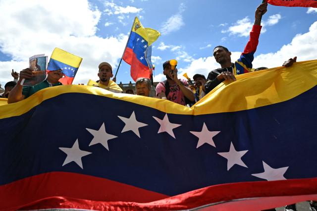 People celebrate at the Bolivar square in Caracas on January 3, 2026, after US forces captured Venezuelan leader Nicolas Maduro. President Donald Trump said Saturday that US forces had captured Venezuela's leader Nicolas Maduro after bombing the capital Caracas and other cities in a dramatic climax to a months-long standoff between Trump and his Venezuelan arch-foe. (Photo by Luis ACOSTA / AFP)