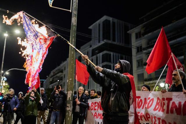 a protester holds a burning US flag during a demonstration organised by members of Greek Comunist party (KKE) against the recent US operation in Venezuela that resulted in the capture of the Venezuelan President, near the US consulate in Thessaloniki on January 3, 2026. (Photo by Aggelos NAKKAS / AFP)
