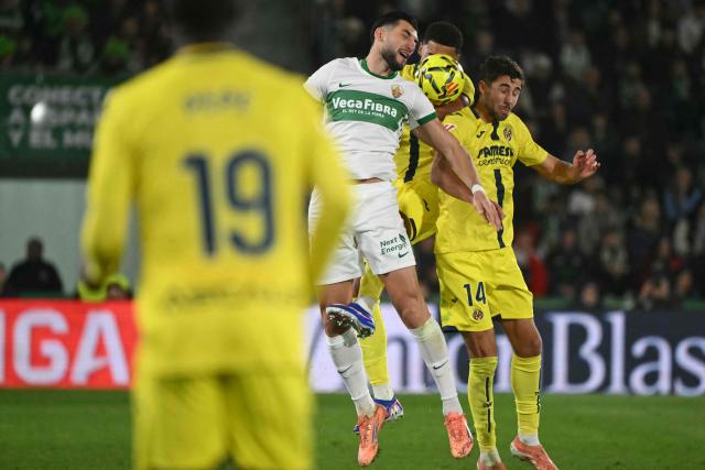 Elche's Spanish forward #10 Rafa Mir and Villarreal's Spanish midfielder #14 Santi Comesana vie for a header during the Spanish League football match between Elche CF and Villarreal CF at Martinez Valero Stadium in Elche on January 3, 2026. (Photo by JOSE JORDAN / AFP)
