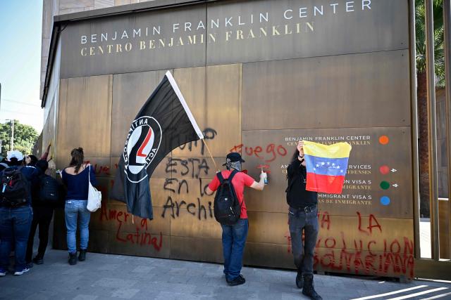 Members of social organizations make a graffiti on the wall of the US embassy as they protest against the US military operation in Venezuela, in Mexico City on January 3, 2026, after US forces captured Venezuelan leader Nicolas Maduro. President Donald Trump said Saturday that US forces had captured Venezuela's leader Nicolas Maduro after bombing the capital Caracas and other cities in a dramatic climax to a months-long standoff between Trump and his Venezuelan arch-foe. (Photo by Alfredo ESTRELLA / AFP)