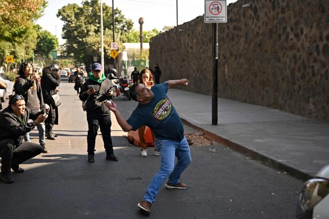 A members of a social organization throws stones at the US embassy as he protests against the US military operation in Venezuela, in Mexico City on January 3, 2026, after US forces captured Venezuelan leader Nicolas Maduro. President Donald Trump said Saturday that US forces had captured Venezuela's leader Nicolas Maduro after bombing the capital Caracas and other cities in a dramatic climax to a months-long standoff between Trump and his Venezuelan arch-foe. (Photo by Alfredo ESTRELLA / AFP)