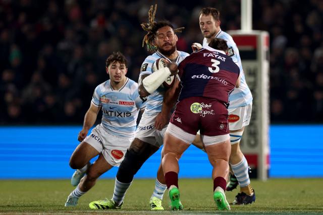 Racing 92' Fijian number 8 Nathan Hughes (C) is tackled by Bordeaux-Begles' South African prop Carlu Johann Sadie during the French Top14 rugby union match between Union Bordeaux-Begles (UBB) and Racing 92 at the Chaban-Delmas Stadium in Bordeaux, south-western France on January 3, 2026. (Photo by ROMAIN PERROCHEAU / AFP)