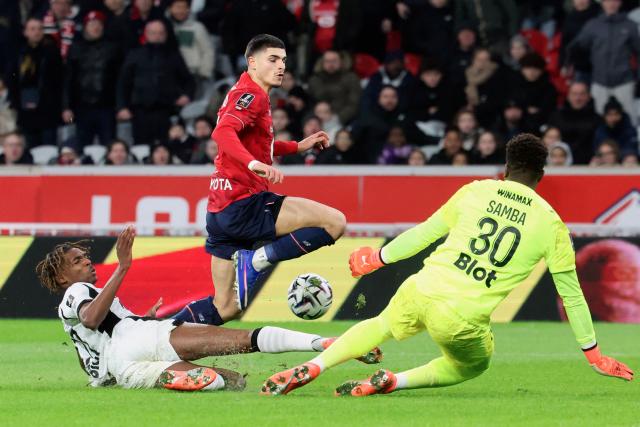 Lille's Belgian forward #07 Matias Fernandez-Pardo (R), Rennes' French defender #97 Jeremy Jacquet and Rennes' French goalkeeper #30 Brice Samba fight for the ball during the French L1 football match between Lille LOSC and Stade Rennais FC at the Stade Pierre-Mauroy in Villeneuve-d'Ascq, northern France, on January 3, 2026. (Photo by Francois LO PRESTI / AFP)