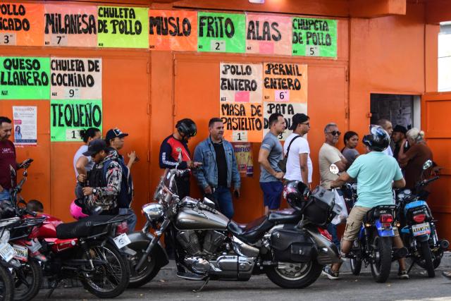 TOPSHOT - People queue at a store to get grouseries in Caracas on January 3, 2026, after US forces captured Venezuelan leader Nicolas Maduro. President Donald Trump said on January 3, 2025, that US forces had captured Venezuela's leader Nicolas Maduro after bombing the capital Caracas and other cities in a dramatic climax to a months-long standoff between Trump and his Venezuelan arch-foe. (Photo by Jacinto OLIVEROS / AFP)