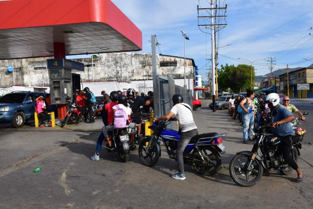 TOPSHOT - Motorcyclists queue at a petrol station to get fuel in Caracas on January 3, 2026, after US forces captured Venezuelan leader Nicolas Maduro. President Donald Trump said on January 3, 2025, that US forces had captured Venezuela's leader Nicolas Maduro after bombing the capital Caracas and other cities in a dramatic climax to a months-long standoff between Trump and his Venezuelan arch-foe. (Photo by Jacinto OLIVEROS / AFP)