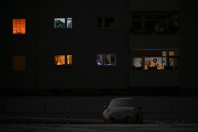 Light is seen through the windows of some apartments of a residential building in the Zehlendorf district in southwest Berlin on early January 4, 2026, after power cables in the area were seriously damaged causing a power outage which left tens of thousands of households in the German capital without electricity. The widespread power outage in southwest Berlin, affecting tens of thousands of households, was deliberately caused with incendiary devices, according to Berlin's Senator for Economic Affairs. It was "clearly" a "deliberate act," Senator Giffey said on January 4. The bridge over the Teltow Canal, where five high-voltage and ten medium-voltage cables were destroyed, had been "rigged with incendiary devices." (Photo by RALF HIRSCHBERGER / AFP)