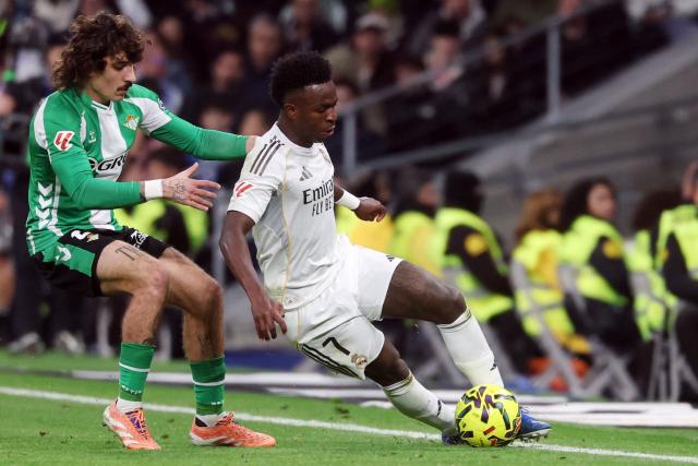 Real Betis' Spanish defender #02 Hector Bellerin (L) and Real Madrid's Brazilian forward #07 Vinicius Junior fight for the ball during the Spanish League football match between Real Madrid CF and Real Betis at Santiago Bernabeu Stadium in Madrid on January 4, 2026. (Photo by Pierre-Philippe MARCOU / AFP)