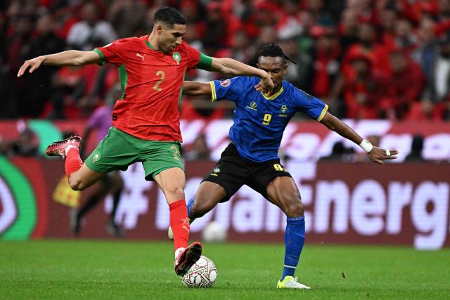 Morocco's defender #02 Achraf Hakimi fights for the ball with Tanzania's forward #09 Selemani Abdallah during the Africa Cup of Nations (CAN) round of 16 football match between Morocco and Tanzania at Prince Moulay Abdallah Stadium in Rabat on January 4, 2026. (Photo by Gabriel BOUYS / AFP)