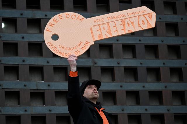 A man holds a symbolic key of freedom as relatives and friends of Ukrainian prisoners of war hold a rally calling to speed up prisoner exchanges, in Kyiv, on January 4, 2026, amid the Russian invasion in Ukraine.  (Photo by Sergei SUPINSKY / AFP)