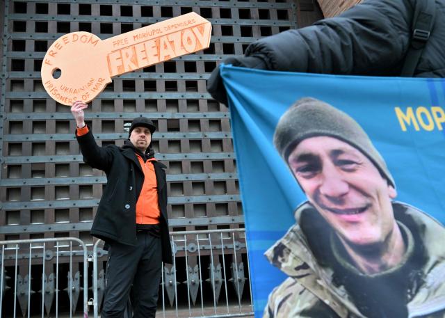 A man holds a symbolic key of freedom as relatives and friends of Ukrainian prisoners of war hold a rally calling to speed up prisoner exchanges, in Kyiv, on January 4, 2026, amid the Russian invasion in Ukraine.  (Photo by Sergei SUPINSKY / AFP)