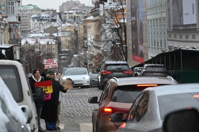 Relatives and friends of Ukrainian prisoners of war hold placards during a rally calling to speed up their exchange, in Kyiv, on January 4, 2026, amid the Russian invasion in Ukraine.  (Photo by Sergei SUPINSKY / AFP)