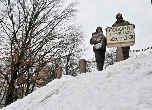 Relatives and friends of Ukrainian prisoners of war hold placards during a rally calling to speed up their exchange, in Kyiv, on January 4, 2026, amid the Russian invasion in Ukraine.  (Photo by Sergei SUPINSKY / AFP)