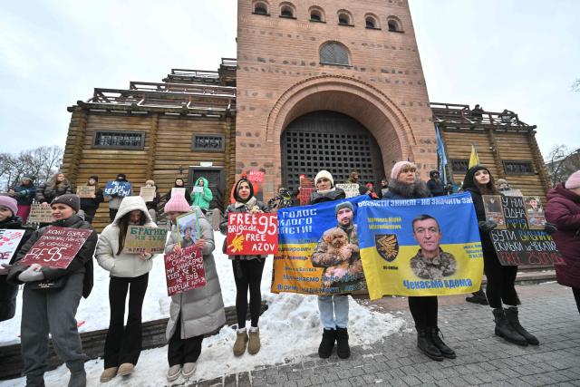 Relatives and friends of Ukrainian prisoners of war hold placards during a rally calling to speed up their exchange, in Kyiv, on January 4, 2026, amid the Russian invasion in Ukraine.  (Photo by Sergei SUPINSKY / AFP)