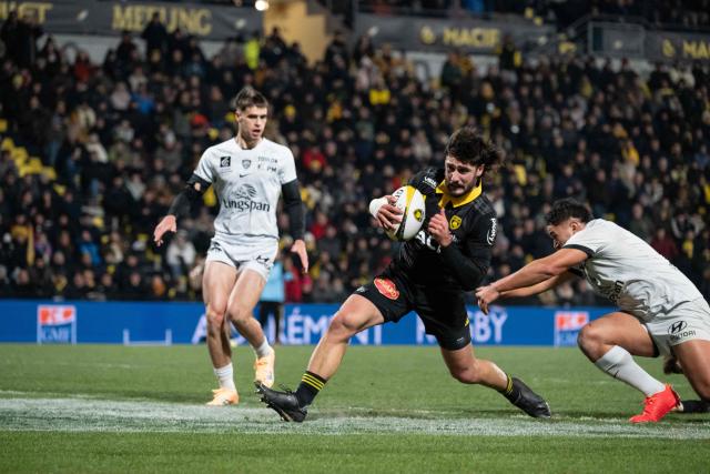 La Rochelle's French centre Jules Favre (C) crosses the line to score a try during the French Top14 rugby union match between Stade Rochelais (La Rochelle) and Rugby Club Toulonnais (Toulon) at The Marcel-Deflandre Stadium in La Rochelle, western France on January 4, 2026. (Photo by XAVIER LEOTY / AFP)