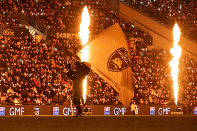 La Rochelle's mascot waves a La Rochelle flag in front of the fans ahead of the French Top14 rugby union match between Stade Rochelais (La Rochelle) and Rugby Club Toulonnais (Toulon) at The Marcel-Deflandre Stadium in La Rochelle, western France on January 4, 2026. (Photo by XAVIER LEOTY / AFP)