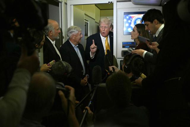 US President Donald Trump (C-R), accompanied by US senator Lindsey Graham, Republican of South Carolina, speaks with reporters aboard Air Force One on his way back to Washington, DC, on January 4, 2026. President Trump is returning to DC after spending the holidays at his Mar-a-Lago residence in Palm Beach, Florida. (Photo by Jim WATSON / AFP)