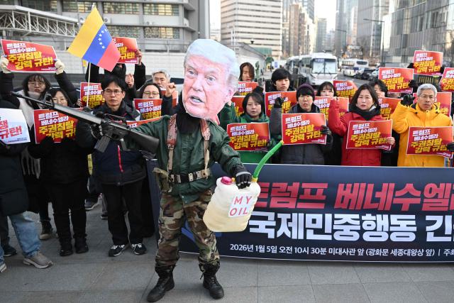 A protester wearing a mask of US President Donald Trump performs during a demonstration condemning the US attack on Venezuela and the seizure of Venezuelan leader Nicolas Maduro, in front of the US embassy in Seoul on January 5, 2026. (Photo by Jung Yeon-je / AFP)