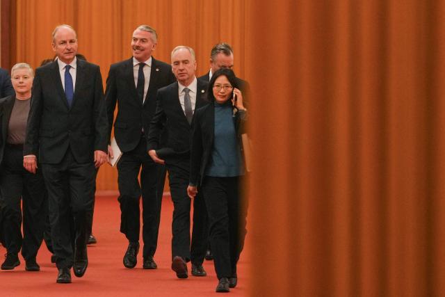 Ireland's Prime Minister Micheal Martin (2nd L) walks with his delegations as they arrive at the Great Hall of the People to meet with China's President Xi Jinping in Beijing on January 5, 2026. (Photo by Andy Wong / POOL / AFP)