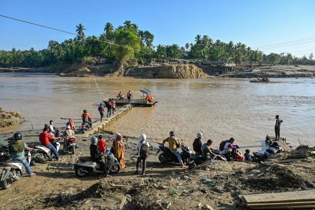 People wait use a rope ferry to cross the Peusangan River following flash floods that destroyed adjacent villages in Bireuen district, Indonesia's Aceh province on January 5, 2026. (Photo by CHAIDEER MAHYUDDIN / AFP/Chaideer MAHYUDDIN / AFP)
