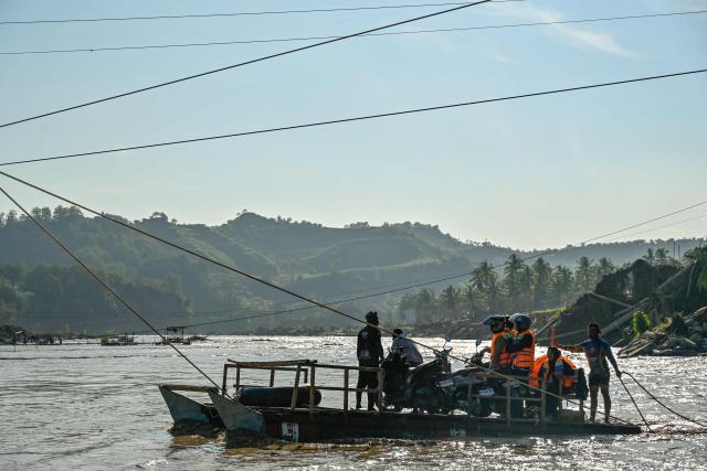 People use a rope ferry to cross the Peusangan River following flash floods that destroyed adjacent villages in Bireuen district, Indonesia's Aceh province on January 5, 2026. (Photo by CHAIDEER MAHYUDDIN / AFP/Chaideer MAHYUDDIN / AFP)