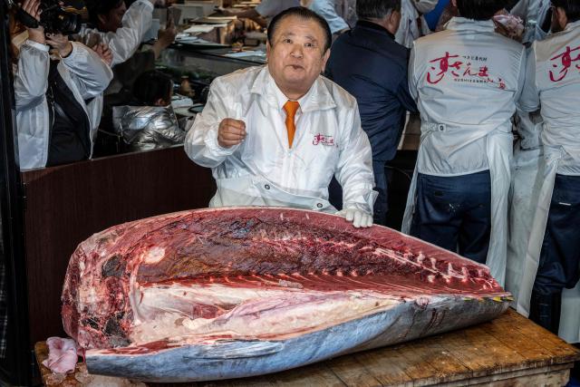 Kiyoshi Kimura (C), president of Kiyomura Corp., the Tokyo-based operator of sushi restaurant chain Sushizanmai, tastes meat of a 243-kilogram bluefin tuna at his main restaurant in Tokyo on January 5, 2026, after the New Year's auction at Toyosu fish market. A Japanese sushi entrepreneur paid a record $3.2 million for a giant bluefin tuna January 5 at an annual prestigious new year auction in Tokyo's main fish market, smashing the previous all-time high. (Photo by Yuichi YAMAZAKI / AFP)