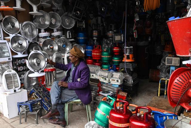 A shopkeeper selling household appliances waits for a customers in Lahore on January 5, 2026. (Photo by Arif ALI / AFP)