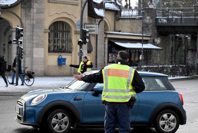Policemen direct traffic at Mexikoplatz in Berlin's Zehlendorf district as traffic lights are not working due to a massive power failure, on January 5, 2026. Police in Berlin said they suspected the far-left Volcano Group of being behind an arson attack that has left tens of thousands of homes in the German capital without power. Early on Saturday morning (January 3, 2026) several high-voltage power cables were spotted in flames on a bridge near a power plant in the southwest of the city. The blaze was quickly put out, but about 45,500 households and 2,200 businesses were left without electricity. Stromnetz Berlin, which runs the city's electricity network, said that it would take until Thursday, January 8, 2026 to reconnect all customers, with freezing temperatures slowing the repair work to the cables. (Photo by RALF HIRSCHBERGER / AFP)
