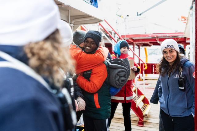 A migrant bids farewell to crew members of the rescue ship "Ocean Viking" operated by the NGO SOS Mediterranee, as he disembarks at the port of Savona, northwestern Italy, on January 5, 2026. 33 migrants were saved by crew members of the rescue ship "Ocean Viking" operated by the NGO SOS Mediterranee on December 31, 2025. They had been stranded on the oil tanker the "Maridive 703" for 5 days in the joint search zone between Malta and Tunisia in international Mediterranean waters. (Photo by Sameer Al-DOUMY / AFP)