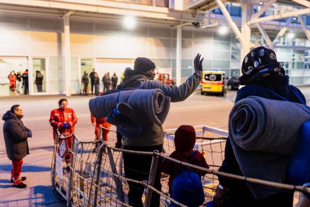 Migrants bid farewell to crew members of the rescue ship "Ocean Viking" operated by the NGO SOS Mediterranee, as they disembark at the port of Savona, northwestern Italy, on January 5, 2026. 33 migrants were saved by crew members of the rescue ship "Ocean Viking" operated by the NGO SOS Mediterranee on December 31, 2025. They had been stranded on the oil tanker the "Maridive 703" for 5 days in the joint search zone between Malta and Tunisia in international Mediterranean waters. (Photo by Sameer Al-DOUMY / AFP)