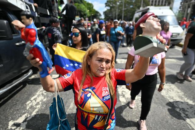 A supporter of ousted Venezuela's President Nicolas Maduro takes part in a rally near the National Assembly in Caracas on January 5, 2026. Venezuela's new parliament opened on January 5 with lawmakers chanting "Let's go Nico!" as they forcibly denounced the recent capture of leftist leader Nicolas Maduro in a US military operation on January 3. (Photo by Juan BARRETO / AFP)