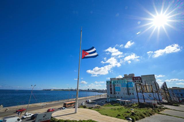 A Cuban national flag flutters in the wind at half-mast in Havana on January 5, 2026. Havana declared two days of national mourning as of January 5 after a total of 32 Cubans were killed during the US attack on Caracas that culminated in the capture of Venezuela's president Nicolas Maduro. (Photo by Adalberto ROQUE / AFP)