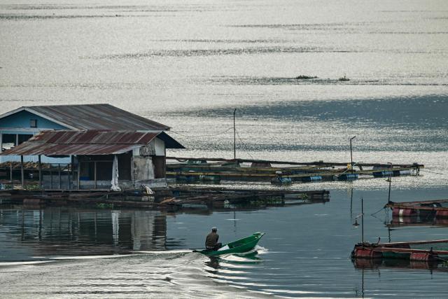 A man paddles a wooden canoe fish at Laut Tawar lake in Takengon, Indonesia's Aceh province on January 6, 2025. (Photo by CHAIDEER MAHYUDDIN / AFP/Chaideer MAHYUDDIN / AFP)