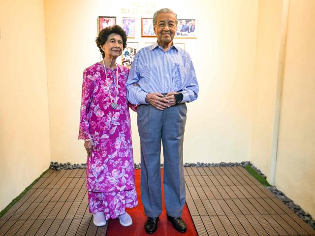 (FILES) This picture taken on June 15, 2025 shows Malaysia's former Prime Minister Mahathir Mohamad and his wife Hasmah Mohamad Ali posing for pictures at an ice cream shop in Shah Alam, on the outskirts of Kuala Lumpur. Malaysia's century-old former prime minister Mahathir Mohamad was brought to the hospital on January 6, 2026 after a fall at his residence, his aide told AFP. (Photo by Mohd RASFAN / AFP)