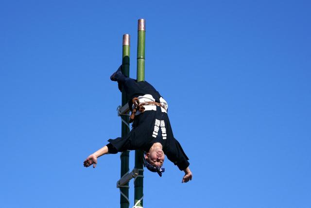 A member of the Edo Firemanship Preservation Association performs acrobatic atop ladders at the Tokyo Fire Department’s New Year fire brigades exercise in Tokyo on January 6, 2026. (Photo by Kazuhiro NOGI / AFP)