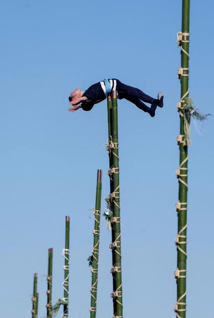 A member of the Edo Firemanship Preservation Association performs acrobatic atop ladders at the Tokyo Fire Department’s New Year fire brigades exercise in Tokyo on January 6, 2026. (Photo by Kazuhiro NOGI / AFP)