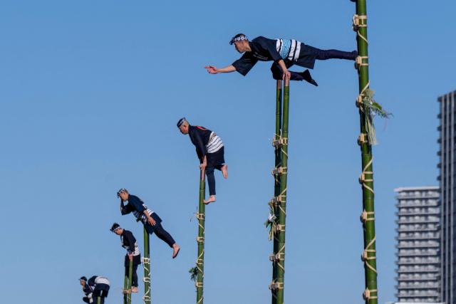 Members of the Edo Firemanship Preservation Association perform acrobatic atop ladders at the Tokyo Fire Department’s New Year fire brigades exercise in Tokyo on January 6, 2026. (Photo by Kazuhiro NOGI / AFP)