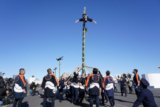 Members of the Edo Firemanship Preservation Association perform acrobatic atop ladders at the Tokyo Fire Department’s New Year fire brigades exercise in Tokyo on January 6, 2026. (Photo by Kazuhiro NOGI / AFP)