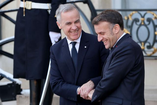 France's President Emmanuel Macron (R) walks with Canada’s Prime Minister Mark Carney after their meeting at the Elysee Palace in Paris, on January 6, 2026, prior to the Coalition of the Willing summit on security guarantees for Ukraine. The summit of the group of Ukraine supporters dubbed the "Coalition of the Willing" is the latest of several meetings planned for the new year as diplomatic efforts to end Europe's deadliest conflict since World War II have gained pace in recent weeks. (Photo by Ludovic MARIN / AFP)