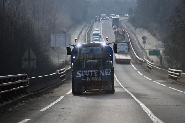 A tractor which reads as "Support us" leads a convoy around Bergerac after its departure from Cancon, south-western France on January 6, 2026, heading to Paris as part of a protest against French government's mandatory culling protocol for cattle herds affected by lumpy skin disease (dermatose nodulaire contagieuse), a viral disease first detected in France in June 2025 that has led to the slaughter of over 3,000 cattle across more than 110 outbreaks nationwide. French government continues its consultations with farmers on January 6, 2026, including those from the powerful FNSEA, hoping to ease the unrest, while on the ground authorities are banning tractor movementsmeasures that farmers promise to defy. (Photo by Christophe ARCHAMBAULT / AFP)