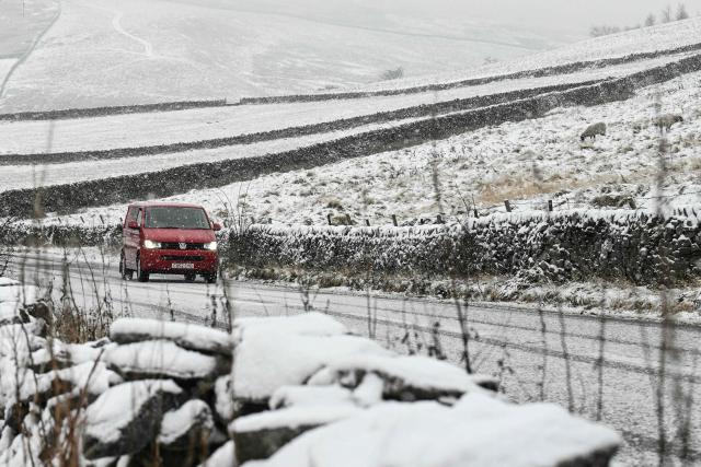 A driver negotiates the snow-covered "Snake Pass" through the Peak District near the town of Glossop, Derbyshire, northern England on January 6, 2026, after a light snow covered the region overnight. The UK's Met Office issued fresh weather warnings for January 5-6 for snow and ice for Scotland, Northern Ireland and parts of northern England and said cold weather health alerts for all English regions would remain in place until January 9. (Photo by Oli SCARFF / AFP)