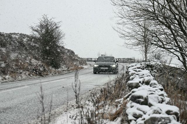 A driver negotiates the snow-covered "Snake Pass" through the Peak District near the town of Glossop, Derbyshire, northern England on January 6, 2026, after a light snow covered the region overnight. The UK's Met Office issued fresh weather warnings for January 5-6 for snow and ice for Scotland, Northern Ireland and parts of northern England and said cold weather health alerts for all English regions would remain in place until January 9. (Photo by Oli SCARFF / AFP)