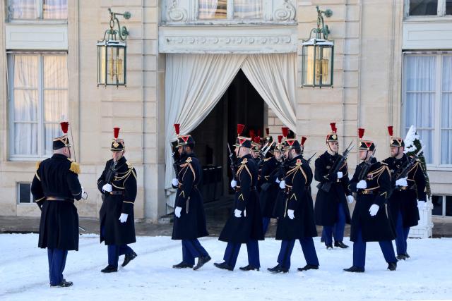 French Republican Guards stand on the snow-covered courtyard during the arrival of world leaders and dignitaries at the Elysee Palace in Paris, on January 6, 2026, prior to the Coalition of the Willing summit on security guarantees for Ukraine. The summit of the group of Ukraine supporters dubbed the "Coalition of the Willing" is the latest of several meetings planned for the new year as diplomatic efforts to end Europe's deadliest conflict since World War II have gained pace in recent weeks. (Photo by Ludovic MARIN / AFP)