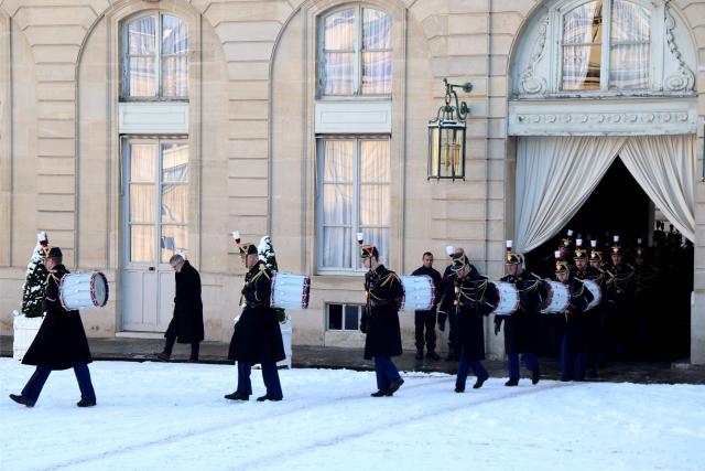 French Republican Guards walk on the snow-covered courtyard during the arrival of world leaders and dignitaries at the Elysee Palace in Paris, on January 6, 2026, prior to the Coalition of the Willing summit on security guarantees for Ukraine. The summit of the group of Ukraine supporters dubbed the "Coalition of the Willing" is the latest of several meetings planned for the new year as diplomatic efforts to end Europe's deadliest conflict since World War II have gained pace in recent weeks. (Photo by Ludovic MARIN / AFP)