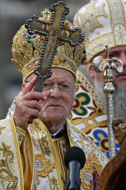 Greek Orthodox Ecumenical Patriarch Bartholomew I of Constantinople prepares to throw wooden cross into the waters of The Golden Horn during a ritual to mark the Epiphany Day in Istanbul on January 6, 2026. (Photo by Ozan KOSE / AFP)